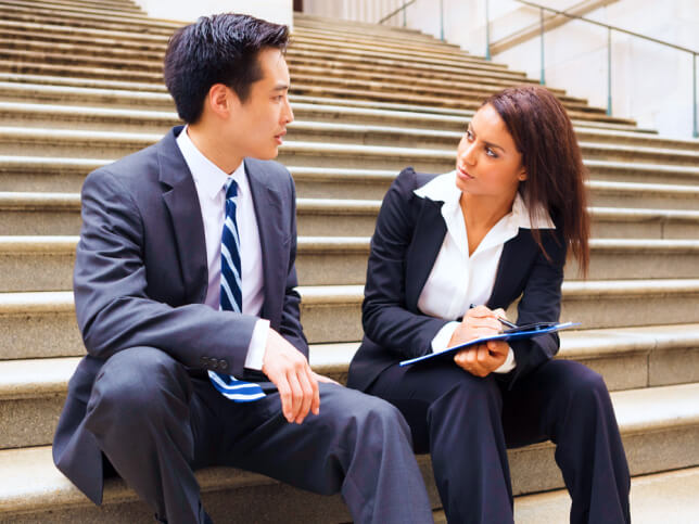 physical therapist talking with legal professional on courthouse steps