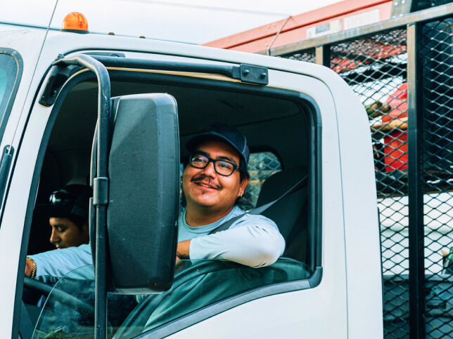 Male wearing glasses driving a landscaping truck
