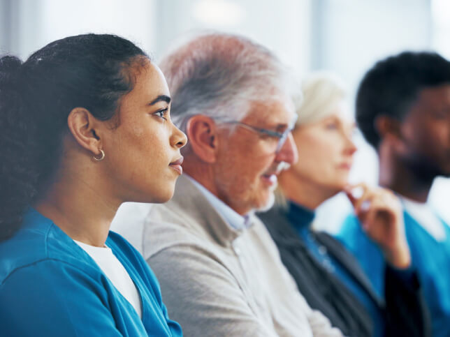 Female medical professional at conference learning how to buy medical malpractice insurance and the different between claims-made and occurrence policies