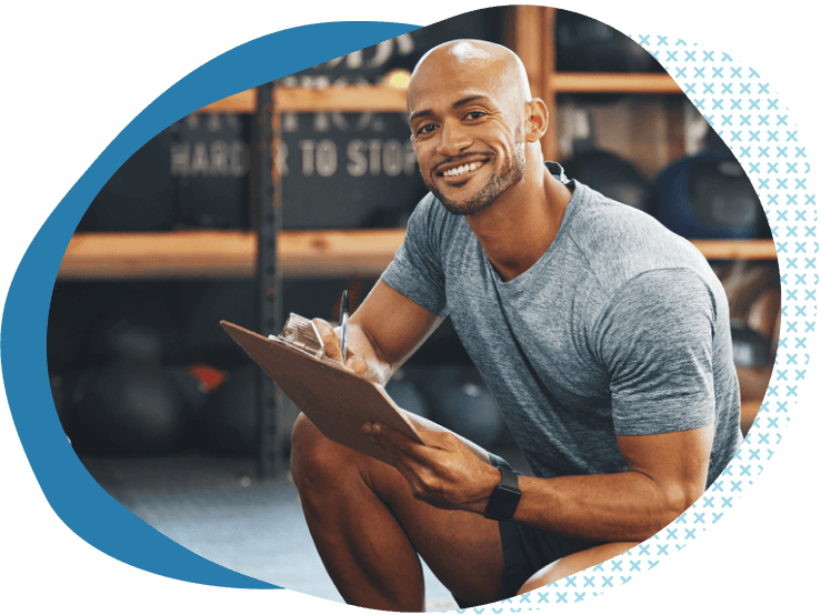 trainer crouched down with clipboard looking at his health club liability insurance