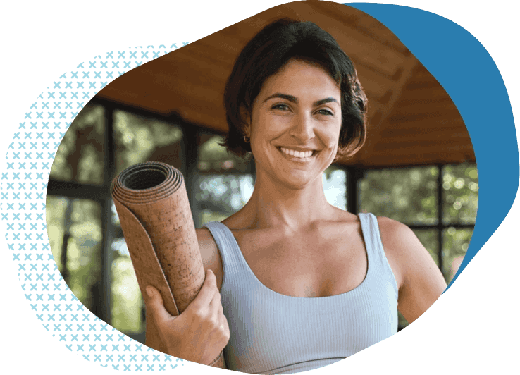 athletic woman holding yoga mat buying yoga instructor and studio insurance