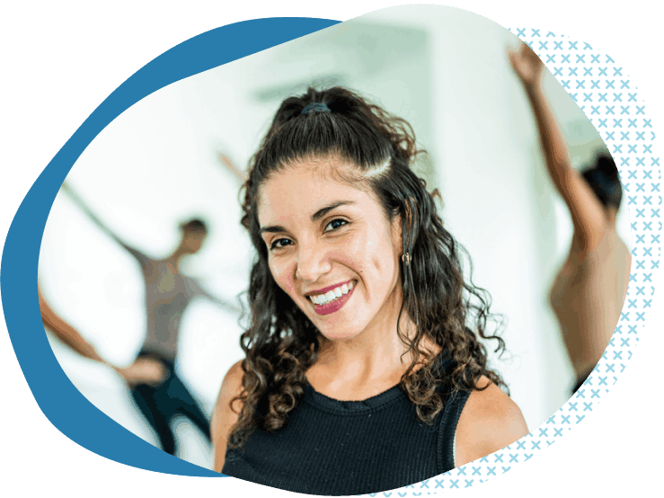 dark haired dance instructor smiling in front of class after buying dance studio insurance