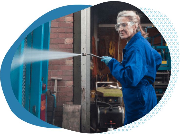 woman in blue coveralls power washing window professional and general liability insurance for pressure washing businesses